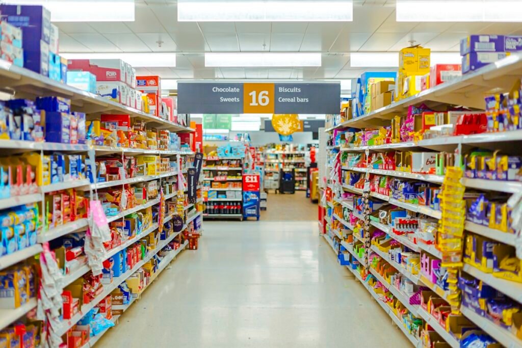 Grocery store aisle lined with product shelves and price labels