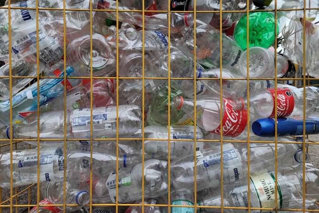 Empty beverage bottles and cans stacked in a collection crate for deposit return