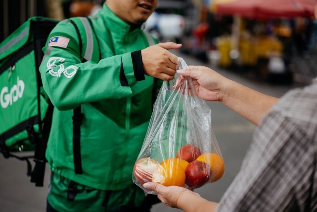 A delivery worker handing a bag of goods to a customer